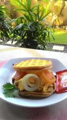 a sandwich on a white plate on a table at Kubu Carik in Legian