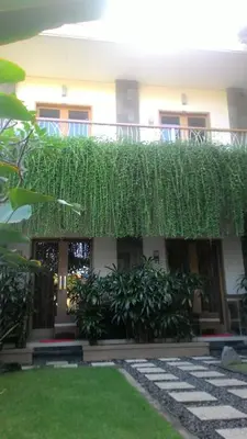 a building with a grass canopy over a yard at Kubu Carik in Legian