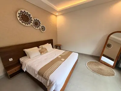 a bedroom with a bed and a mirror on the wall at Villa Leyan 1 Semer - Between Seminyak & Canggu in Seminyak