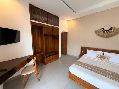 a bedroom with a bed and a desk and a television at Villa Leyan 1 Semer - Between Seminyak & Canggu in Seminyak