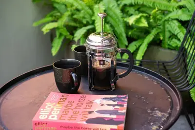 a book and a cup of coffee on a table at Family Luxury 5bd Villa Parking X Walk 2 Potato Head in Seminyak