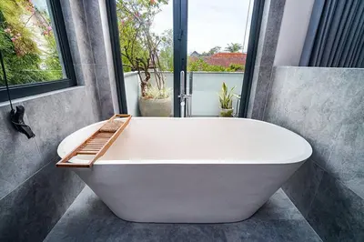 a white bath tub in a bathroom with a window at Family Luxury 5bd Villa Parking X Walk 2 Potato Head in Seminyak