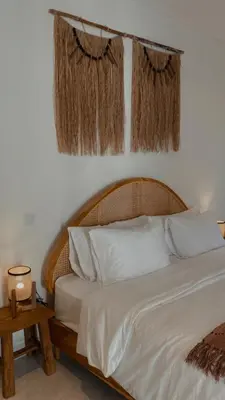 a bedroom with a bed with white sheets and curtains at Villa Hope Bali in Kerobokan