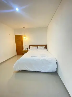 a bedroom with a white bed in a white room at Home Stay Room In Bali Near Sanur Beach in Sanur