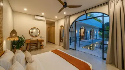 a bedroom with a white bed and a large window at Villa Unna in Canggu by Elite Havens in Canggu
