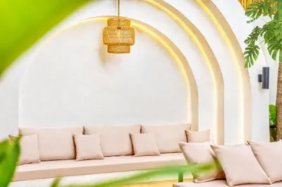 a white couch in front of a white wall with a rainbow at Villa Orlando - Brand New 9BR Jacuzzi Cinema in Seminyak
