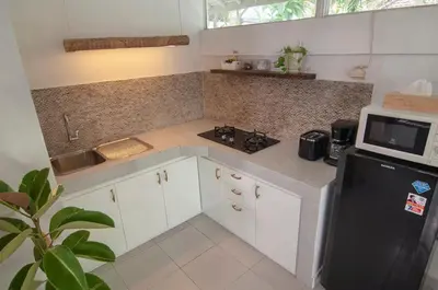 a kitchen with a black refrigerator and a microwave at AMAZING 1 BR Villa Private Pool walk to beach in Seminyak