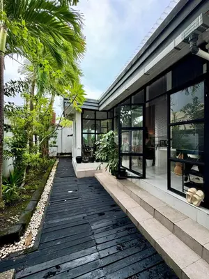 an external view of a house with a wooden walkway at Aesthetic Villa Central Canggu With an Office in Canggu