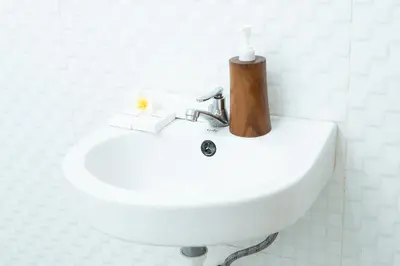 a bathroom sink with a soap dispenser on top of it at The Kifaraju Nusa Dua Bali in Nusa Dua