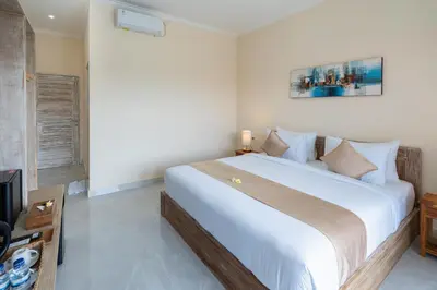 a bedroom with a large white bed in a room at The Kifaraju Nusa Dua Bali in Nusa Dua