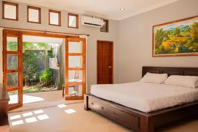 a bedroom with a bed and a painting on the wall at Villa with private pool and garden in Nusa Dua 3BR in Nusa Dua