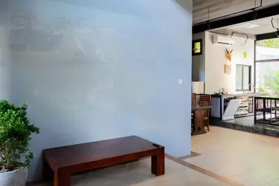 a living room with a wooden bench next to a wall at Villa with private pool and garden in Nusa Dua 3BR in Nusa Dua