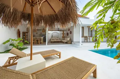 a patio with chairs and an umbrella and a pool at Casa Kokoon - NEW Bright & Quiet 2BR Mertanadi Seminyak with Private Pool and Parking in Seminyak