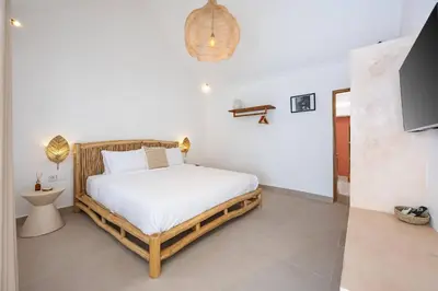 a bedroom with a bed and a tv in a room at Casa Kokoon - NEW Bright & Quiet 2BR Mertanadi Seminyak with Private Pool and Parking in Seminyak