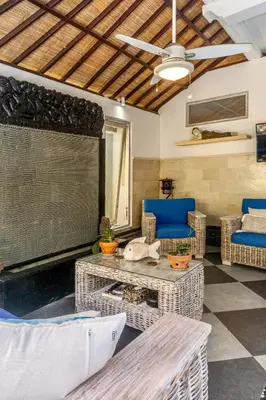a living room with wicker furniture and a ceiling at Villa Nari - GG100X Seminyak, Bali in Seminyak