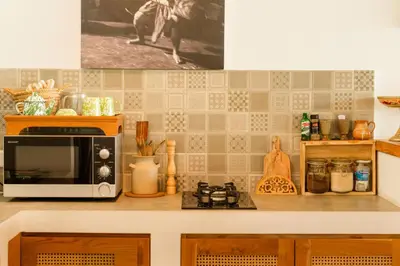 a kitchen counter with a microwave on top of it at Villa Kepompong Seminyak - 1BR Private Pool Villa in Seminyak