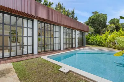 a swimming pool in the backyard of a house at Mediterranean 2BR Villa Ellure Ember with Pool & Lush Garden in Jimbaran