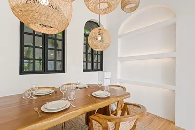 a dining room with a wooden table and chairs at Mediterranean 2BR Villa Ellure Ember with Pool & Lush Garden in Jimbaran
