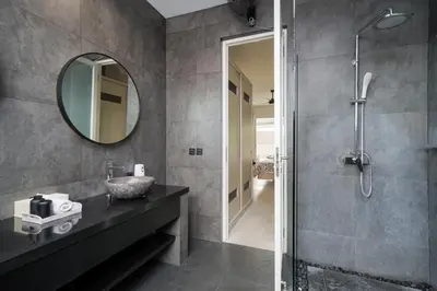 a bathroom with a sink and a shower with a mirror at Villa Stella Seminyak in Seminyak