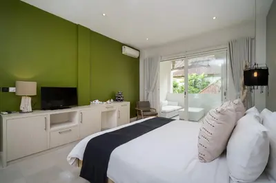 a bedroom with a white bed and a green wall at Villa Stella Seminyak in Seminyak