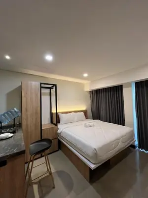 a bedroom with a bed and a desk and a chair at Alzeto Coliving in Legian