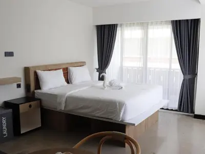 a bedroom with a bed and a large window at Alzeto Coliving in Legian