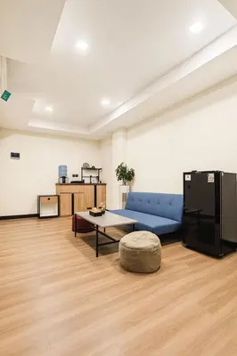 a living room with a blue couch and a table at Alzeto Coliving in Legian