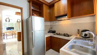 a kitchen with a white refrigerator and a sink at YY Villa Seminyak - 4BR Luxury Private Villa in Seminyak
