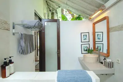 a bedroom with a bed and a sink and a mirror at COZY 2 BR Villa Private POOL walk to the beach in Badung