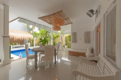 a dining room with a table and chairs and a pool at Smile - One Bedroom Villa in the Seminyak center in Seminyak