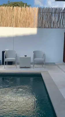 two chairs and a swimming pool in a backyard at Wakajima House Kuta Utara in Kerobokan