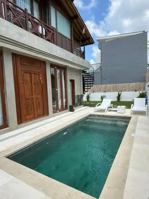a swimming pool in front of a house at Wakajima House Kuta Utara in Kerobokan