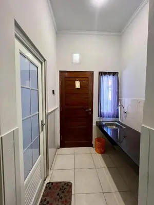 a bathroom with a wooden door and a sink at Thapleuk Residence in Nusa Dua
