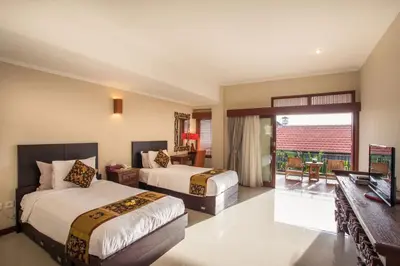 a hotel room with two beds and a balcony at Villa Tantri in Kerobokan