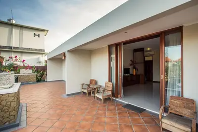 a patio with a table and chairs and a building at Villa Tantri in Kerobokan