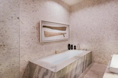 a bathroom with a tub and a picture on the wall at Cicada Luxury Townhouses in Seminyak