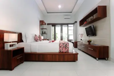 a bedroom with a large bed and a television at Bali mansion kuta in Legian