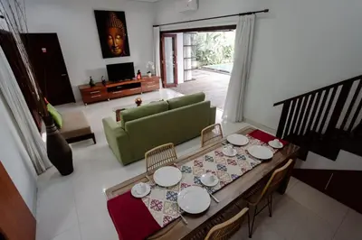 a living room with a table and a green couch at Bali mansion kuta in Legian