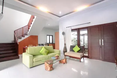 a living room with a green couch and a table at Bali mansion kuta in Legian