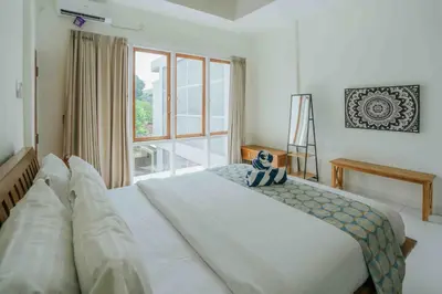 a bedroom with a bed and a large window at Shantia Villa 10 minutes walk to Double Six Beach Seminyak in Seminyak