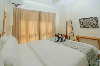 a bedroom with a white bed and a window at Shantia Villa 10 minutes walk to Double Six Beach Seminyak in Seminyak