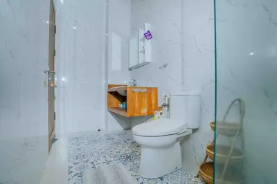 a bathroom with a toilet and a glass shower at Shantia Villa 10 minutes walk to Double Six Beach Seminyak in Seminyak