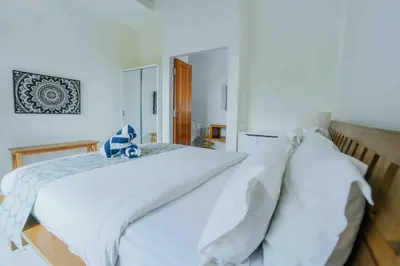 a bedroom with a white bed with white sheets at Shantia Villa 10 minutes walk to Double Six Beach Seminyak in Seminyak