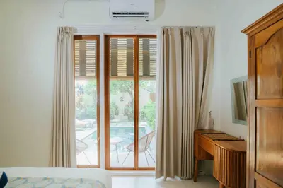 a bedroom with a bed and a desk and a window at Shantia Villa 10 minutes walk to Double Six Beach Seminyak in Seminyak