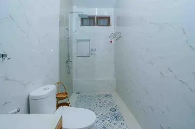a white bathroom with a toilet and a shower at Shantia Villa 10 minutes walk to Double Six Beach Seminyak in Seminyak