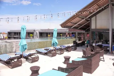 a group of lounge chairs and umbrellas on a patio at Watermark Hotel & Spa Bali in Jimbaran