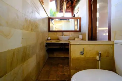a bathroom with a sink and a toilet and a mirror at Villa Jepun Seminyak in Canggu
