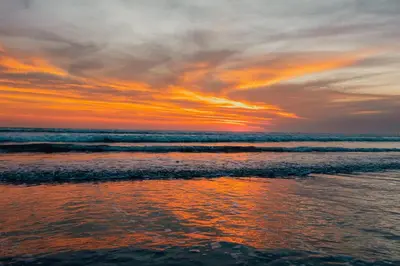 a sunset on the beach with the ocean at Central Cozy Villa 3BR 5min walk to shops, beach in Legian