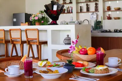 a table with plates of food and fruit on it at Villa Sinergi Seminyak 6 in Seminyak