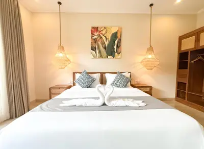 a bedroom with two swans towels on a bed at Villa Sinergi Seminyak 6 in Seminyak